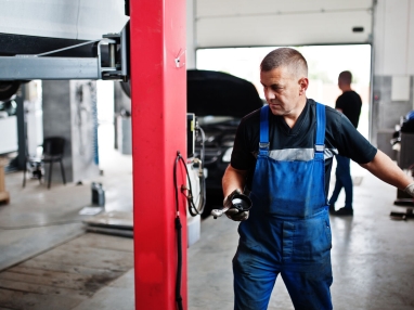 Técnico verificando peça retirada do motor.