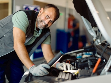 Técnico verificando peça retirada do motor.